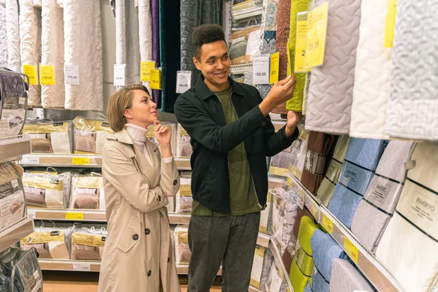 Interracial couple selecting bedding in a store aisle. Retail data and research methods